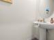 Stylish powder room featuring a pedestal sink and decorative accents at 2925 Evergreen Elm Pass, Wesley Chapel, FL 33543