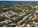 A broad aerial view of the neighborhood, featuring lush greenery and various houses under a blue sky at 3041 Oak View Dr, Palm Harbor, FL 34684