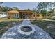 Backyard view of the home, landscaping, fire pit, and outdoor living space at 3041 Oak View Dr, Palm Harbor, FL 34684
