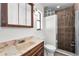 Bathroom showcasing a vanity with a tile shower and glass block window at 3041 Oak View Dr, Palm Harbor, FL 34684