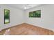 Bright bedroom with two windows, wood floors, and white walls at 3041 Oak View Dr, Palm Harbor, FL 34684
