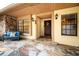 Inviting front porch with stone flooring, comfortable seating, decorative wreath, and stylish exterior lighting at 3041 Oak View Dr, Palm Harbor, FL 34684