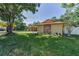 Charming single-story home featuring a stone facade, lush landscaping, and a long driveway leading to an attached garage at 3041 Oak View Dr, Palm Harbor, FL 34684