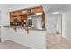 Well-lit kitchen featuring wood cabinets, a breakfast bar, stainless steel appliances, and tile flooring at 3041 Oak View Dr, Palm Harbor, FL 34684