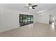 Living room with ceiling fan and tiled floors that lead to screened in porch at 3041 Oak View Dr, Palm Harbor, FL 34684
