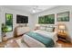 Bright main bedroom featuring a ceiling fan, a dresser with a TV, and an ensuite bathroom at 3041 Oak View Dr, Palm Harbor, FL 34684
