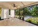 View of the screened porch with tile flooring, ceiling fan, and view of the backyard at 3041 Oak View Dr, Palm Harbor, FL 34684
