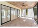 View of the screened porch with tile flooring, ceiling fan, and sliding doors at 3041 Oak View Dr, Palm Harbor, FL 34684