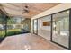 View of the screened porch with tile flooring, ceiling fan, and sliding doors at 3041 Oak View Dr, Palm Harbor, FL 34684