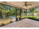 View of the screened porch with tile flooring, ceiling fan, and view of the backyard at 3041 Oak View Dr, Palm Harbor, FL 34684