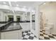 Elegant bathroom featuring a black and white tile floor, white cabinets and a large mirror at 3105 W San Isidro St, Tampa, FL 33629