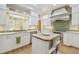 Bright kitchen featuring white cabinets, a central island, and stylish tile accents at 3105 W San Isidro St, Tampa, FL 33629