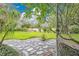Landscaped backyard features lush greenery and a beautiful stone patio area, creating a serene outdoor oasis at 3207 Hilltop Ln, Largo, FL 33770