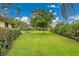 Well-manicured lawn with manicured hedges and shade trees in a spacious backyard setting at 3207 Hilltop Ln, Largo, FL 33770