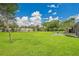 Expansive backyard featuring lush green grass, beautiful landscaping, and mature trees at 3207 Hilltop Ln, Largo, FL 33770