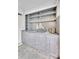 The wet bar features custom cabinetry, tile backsplash, and shelving at 3207 Hilltop Ln, Largo, FL 33770