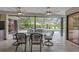Outdoor dining set near the screened-in pool, perfect for entertaining at 3207 Hilltop Ln, Largo, FL 33770