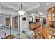 Open dining area with glass table, decorative chandelier, and access to outdoor living spaces at 3207 Hilltop Ln, Largo, FL 33770