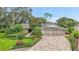 Charming exterior of a home featuring lush landscaping and a paver driveway at 3207 Hilltop Ln, Largo, FL 33770