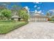Beautiful home with manicured lawn, mature trees, and brick paver driveway at 3207 Hilltop Ln, Largo, FL 33770