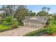 Well-maintained home featuring a paver driveway, 3 car garage, and landscaped front yard at 3207 Hilltop Ln, Largo, FL 33770