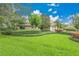 Well-maintained front yard with lush green grass and mature trees at 3207 Hilltop Ln, Largo, FL 33770