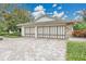 Spacious garage with decorative doors and a paver driveway at 3207 Hilltop Ln, Largo, FL 33770