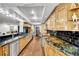 Galley kitchen with wood cabinets, black backsplash, granite countertop, stainless steel appliances at 3207 Hilltop Ln, Largo, FL 33770