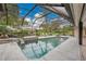 The screened pool features a unique rock waterfall, beautiful landscaping and peaceful seating areas at 3207 Hilltop Ln, Largo, FL 33770