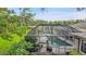A screened pool sits in the backyard surrounded by tropical foliage at 3207 Hilltop Ln, Largo, FL 33770