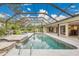 The pristine pool with waterfall feature is completely screened in and surrounded by beautiful landscaping at 3207 Hilltop Ln, Largo, FL 33770