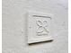 A close-up detail of a branded block is affixed to a light colored textured wall at 3207 Hilltop Ln, Largo, FL 33770