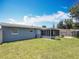 Back exterior view of a home featuring a screened-in porch and large backyard with mature trees at 3271 36Th N St, St Petersburg, FL 33713