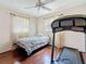 A bright bedroom with a treadmill, bed, and two windows for natural light at 3271 36Th N St, St Petersburg, FL 33713