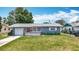 Charming single-story home featuring a well-manicured lawn, red front door, and attached garage at 3271 36Th N St, St Petersburg, FL 33713
