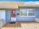 Inviting front porch featuring a red door, textured tile flooring, and blue brick facade at 3271 36Th N St, St Petersburg, FL 33713