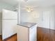 Bright kitchen area featuring hardwood floors, a ceiling fan, white appliances, and a convenient door at 3271 36Th N St, St Petersburg, FL 33713