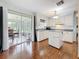 Bright kitchen with white cabinets, hardwood floors, and sliding glass door to sunroom at 3271 36Th N St, St Petersburg, FL 33713