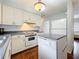 Cozy kitchen features white cabinets, hardwood floors, and white appliances with a white dishwasher and electric range at 3271 36Th N St, St Petersburg, FL 33713