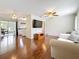 Open living room featuring hardwood floors, a ceiling fan, and a large television at 3271 36Th N St, St Petersburg, FL 33713