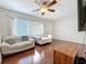 A bright living room with hardwood floors, white sofas, natural light, and a ceiling fan at 3271 36Th N St, St Petersburg, FL 33713