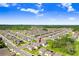 Aerial view of a home in a vibrant community with well-manicured lawns and plentiful green spaces at 36312 Garden Wall Way, Zephyrhills, FL 33541