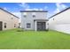Backyard featuring green grass, a screen enclosed porch, and the exterior of the home at 36312 Garden Wall Way, Zephyrhills, FL 33541
