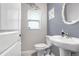 Cozy half-bathroom with pedestal sink, decorative mirror, and neutral paint at 36312 Garden Wall Way, Zephyrhills, FL 33541