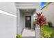 Inviting front porch featuring a decorative wreath on the front door and colorful landscaping at 36312 Garden Wall Way, Zephyrhills, FL 33541