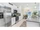 Bright kitchen with stainless steel appliances, granite countertops, and adjacent dining area at 36312 Garden Wall Way, Zephyrhills, FL 33541