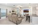 Bright and inviting living room with a large TV and bar seating in the kitchen area at 36312 Garden Wall Way, Zephyrhills, FL 33541