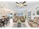 Open concept living room with comfortable seating, a ceiling fan, and access to the dining area at 36312 Garden Wall Way, Zephyrhills, FL 33541