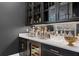 Stylish bar area featuring dark cabinetry, a wine cooler, marble countertop, and mirrored backsplash at 4807 W Longfellow Ave, Tampa, FL 33629