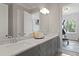A bathroom with double sinks, marble countertops, and a view into the exercise room at 4807 W Longfellow Ave, Tampa, FL 33629